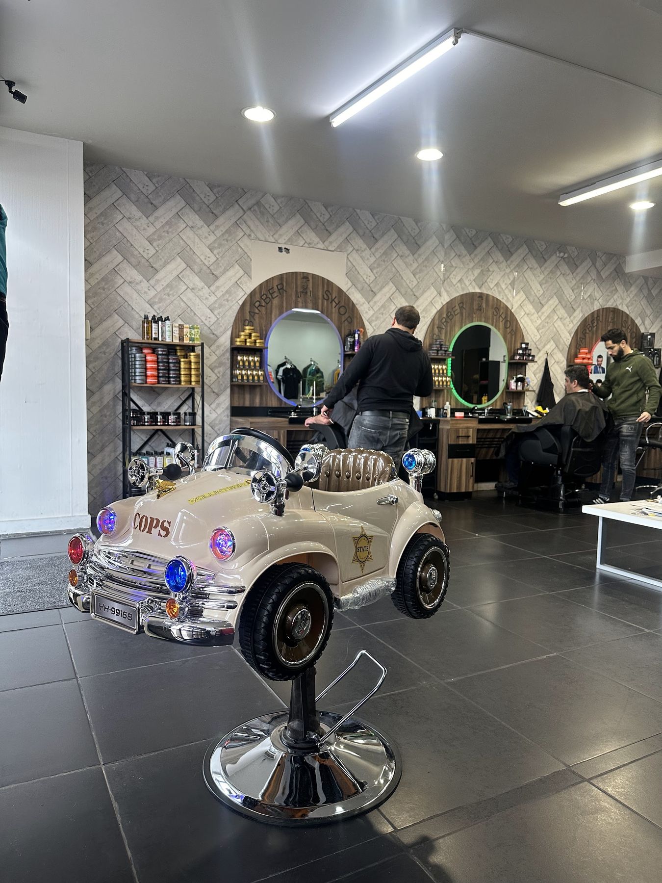 De salon met vooraan een kinderstoel in de vorm van een politieauto