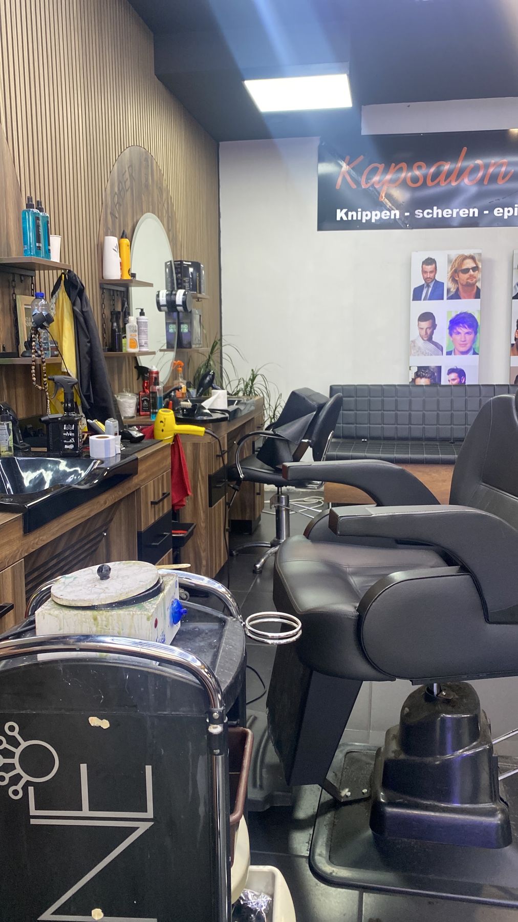 Een kappersstoel en werkplek voor de houten lamellenwand